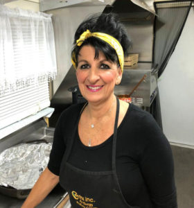Valerie, the owner of Serrianni's, smiling in the kitchen