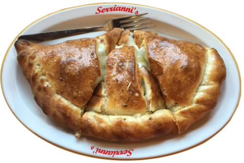 Crispy Italian calzone oozing cheese on a Serriani's plate with a silver fork