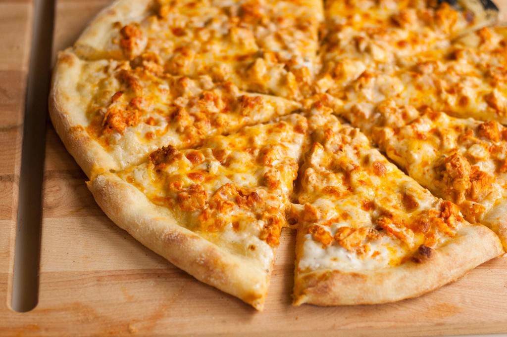 another image of a buffalo chicken pizza, baked to perfection, lightly browned cheese, nice chunks of chicken meat, and some herbs sprinkled on top and of course, let us not forget about that unforgettable NY style pizza crust, chewy and crisp all in the right places.
