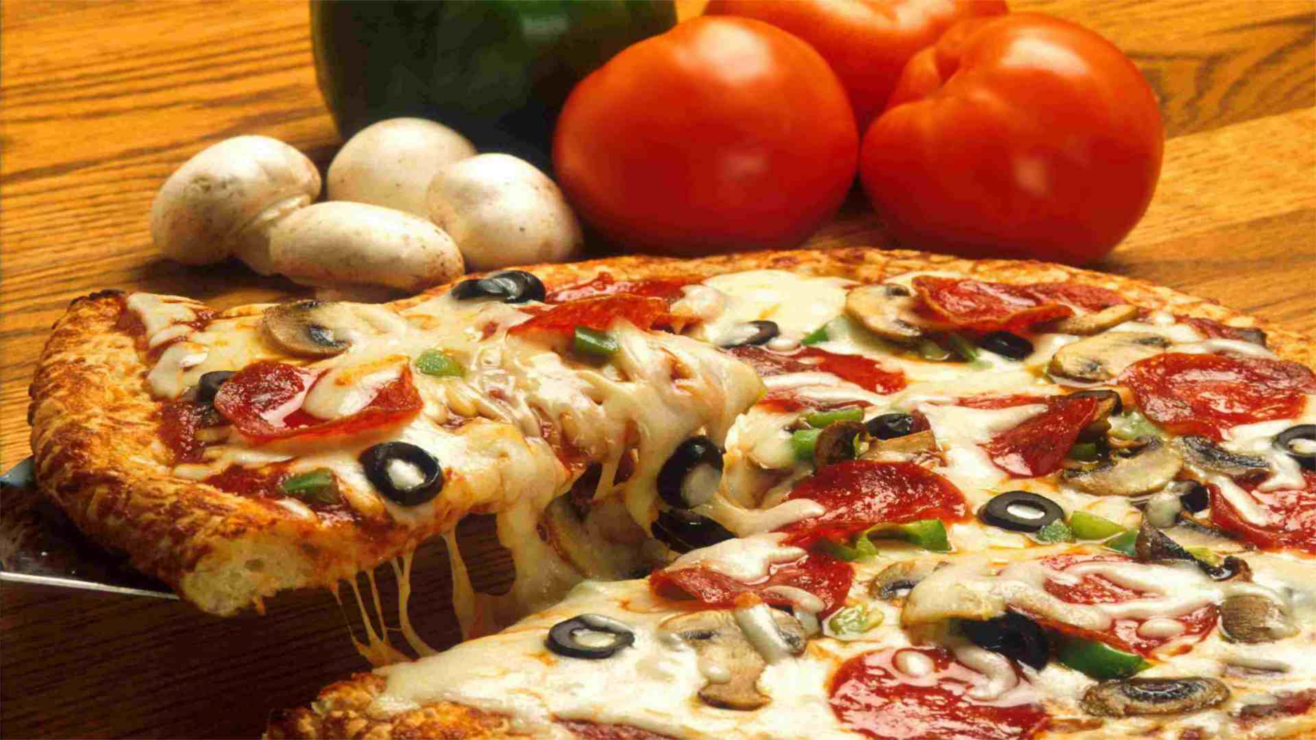 An Image of a Pizza with lots of different toppings, it look delicious!!